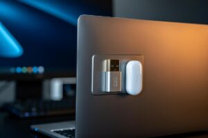 Illustration von einem Laptop mit mehreren kleinen, magnetisch befestigten Gegenständen wie USB-Sticks und einer Zugangskarte an seiner Rückseite